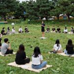 노들섬 잔디마당에서 펼쳐지는 서울서커스페스티벌의 다양한 공연 장면, 관객들이 돗자리에 앉아 관람하고 있음