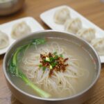 미사리밀빛초계국수 본점 지점 완벽 비교 미사리밀빛초계국수 본점에서 맛본 시원한 초계국수와 비빔국수, 메밀만두가 담긴 테이블 사진