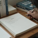 과학고 자소서 독서 활동 작성 예시와 함께 책상 위에 놓인 과학 서적과 노트