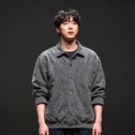 배우 최상엽이 연극 무대에서 연기하는 모습, 진지한 표정과 자세가 돋보인다